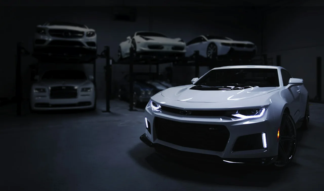 White sports coupe in an automotive storage facility