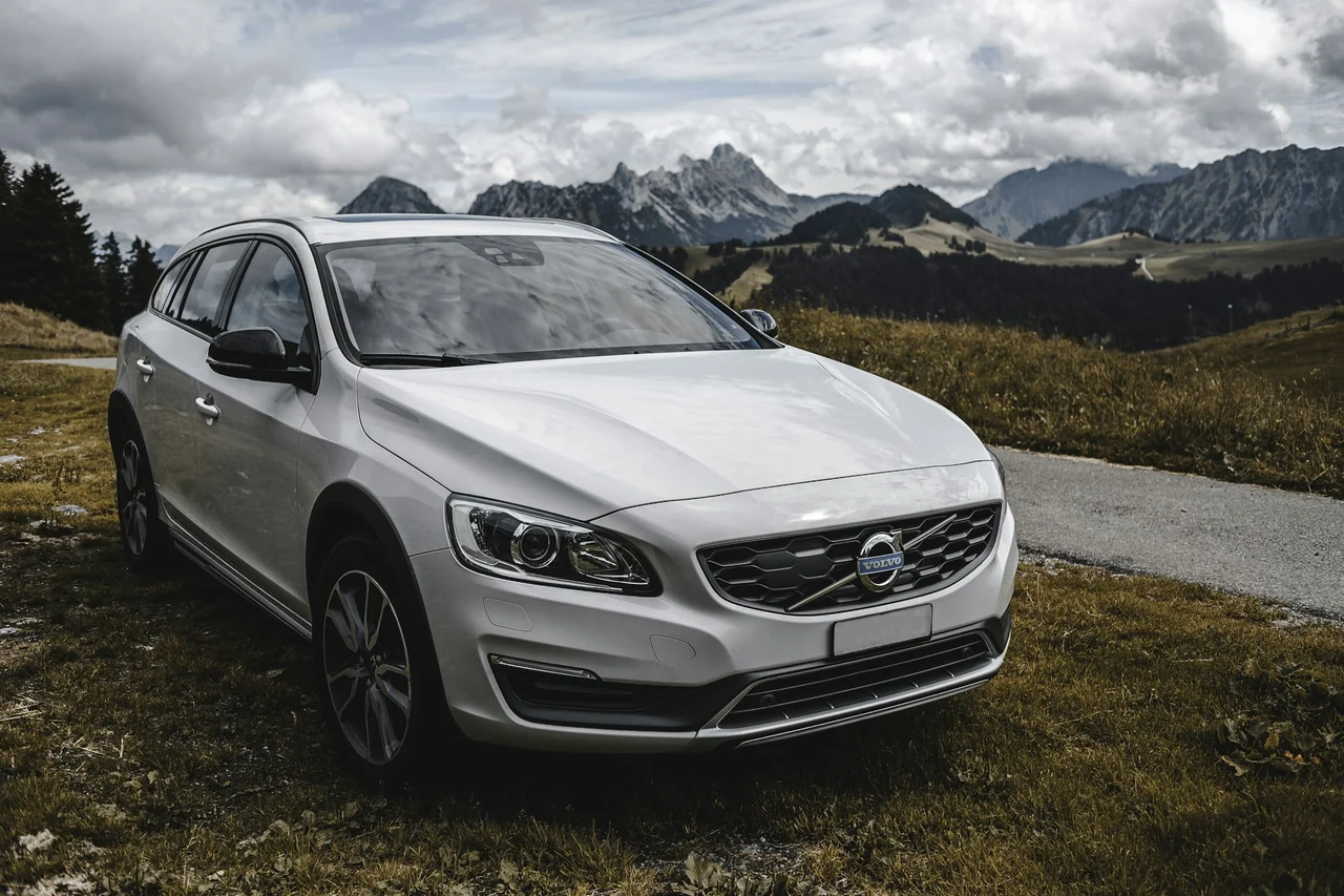 White Volvo SUV beside a scenic mountain road